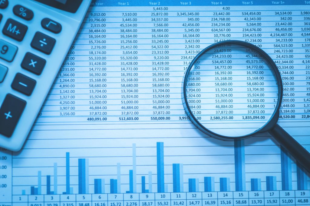 Spreadsheet bank accounts accounting with calculator and magnifying glass.